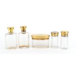 Set of five cut glass jars and bottles with silver gilt lids by Apsrey & Co London, London 1911, the