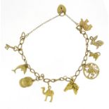 9ct gold charm bracelet with mostly 9ct gold charms including jockey cap, camel, dolphin and