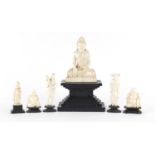 Asian ivory carvings including three Buddha's and a fisherman all raised on ebonised stands, the