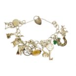Silver charm bracelet with a selection of mostly silver charms including carriage, church, mouse