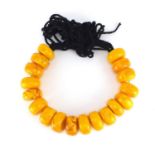 Tribal interest pressed amber coloured bead necklace, each bead approximately 6cm in diameter,