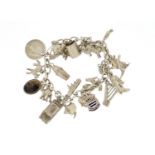 Silver charm bracelet with a selection of mostly silver charms including harp, cocktail shaker,