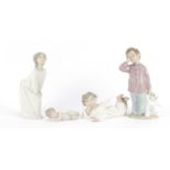 Lladro and Nao china including young boy with a teddy bear and cherubs, the largest 19.5cm high :For