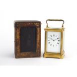 Large gilt brass cased carriage clock striking on a gong, with enamelled dial having Roman