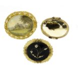 Three Victorian brooches including moss agate and a hand painted cottage view, the largest 6cm