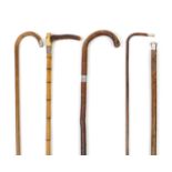 Four walking sticks with silver mounts and a Swain and Co silver mounted riding crop, the largest