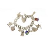 Silver charm bracelet with a selection of mostly silver charms including toaster, stove, spinning