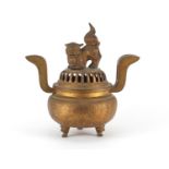Chinese gilt metal tripod incense burner with twin handles and pierced dog-of-foo design lid, 34cm