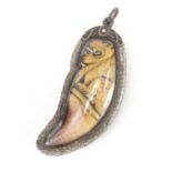 Ivory tooth carved with a mythical animal, encased in a silver coloured metal pendant mount, overall