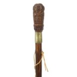 Exotic wood walking stick having a coquilla nut pommel carved with Roman soldiers and an emperors