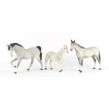 Two Beswick matt grey horses and a Connemara dapple grey example, the largest 20cm high :For Further