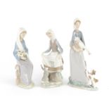 Three Lladro figurines including a girl with a goose and puppy, the largest 27cm high :For Further