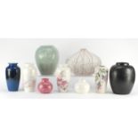 Nine Poole pottery vases including a pair decorated with flowers and an abstract design example, the