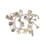 Silver charm bracelet with a selection of mostly silver charms including classic car, fish, lion and