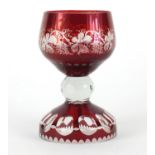 Bohemian ruby glass table goblet, the bowl etched with vines and grapes on a faceted base, 22cm high