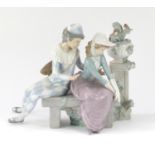 Nao china figure group of a young harlequin and girl seated beside birds, 23cm high :For Further