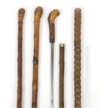 Four walking sticks comprising two Chinese carved bamboo examples, a sword type stick and one