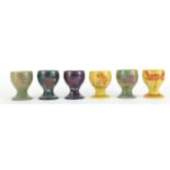 Set of six Johnathon Chiswell Jones lustre egg cups, hand painted with stylised fish, flowers and