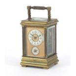Miniature brass cased carriage alarm clock with subsidiary dial and enamelled chapter rings, both