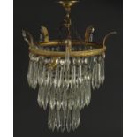 Circular brass four tier chandelier with cut glass drops, 35cm high x 22cm in diameter :For