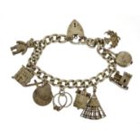 Silver charm bracelet with a selection of mostly silver charms including a church, teddy bear and