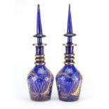 Pair of blue glass decanters made for the Islamic market with gilded decoration, each 48.5cm high :