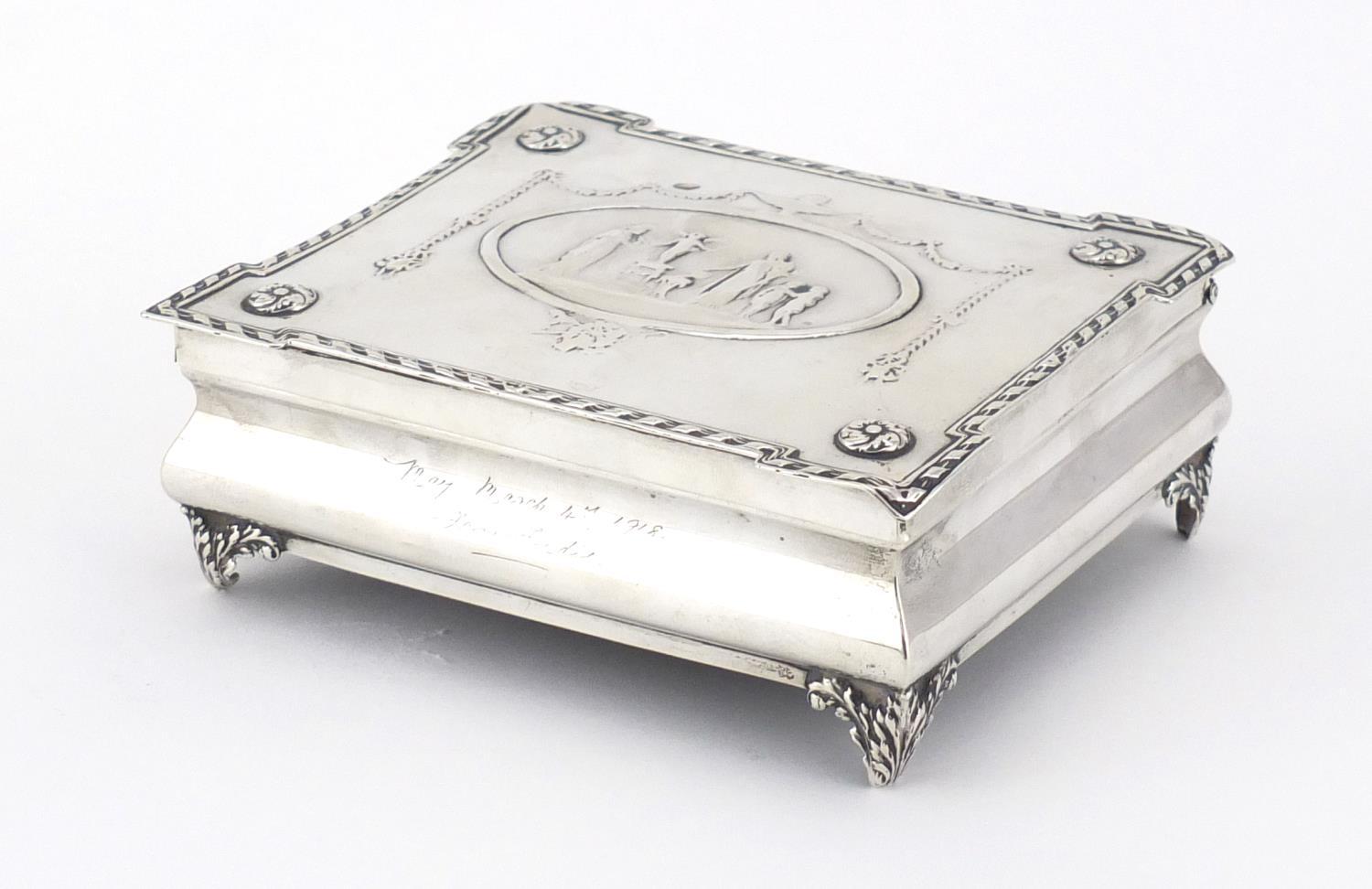 Rectangular silver jewel box by William Comyns, the hinged lid embossed with maidens, putti, swags