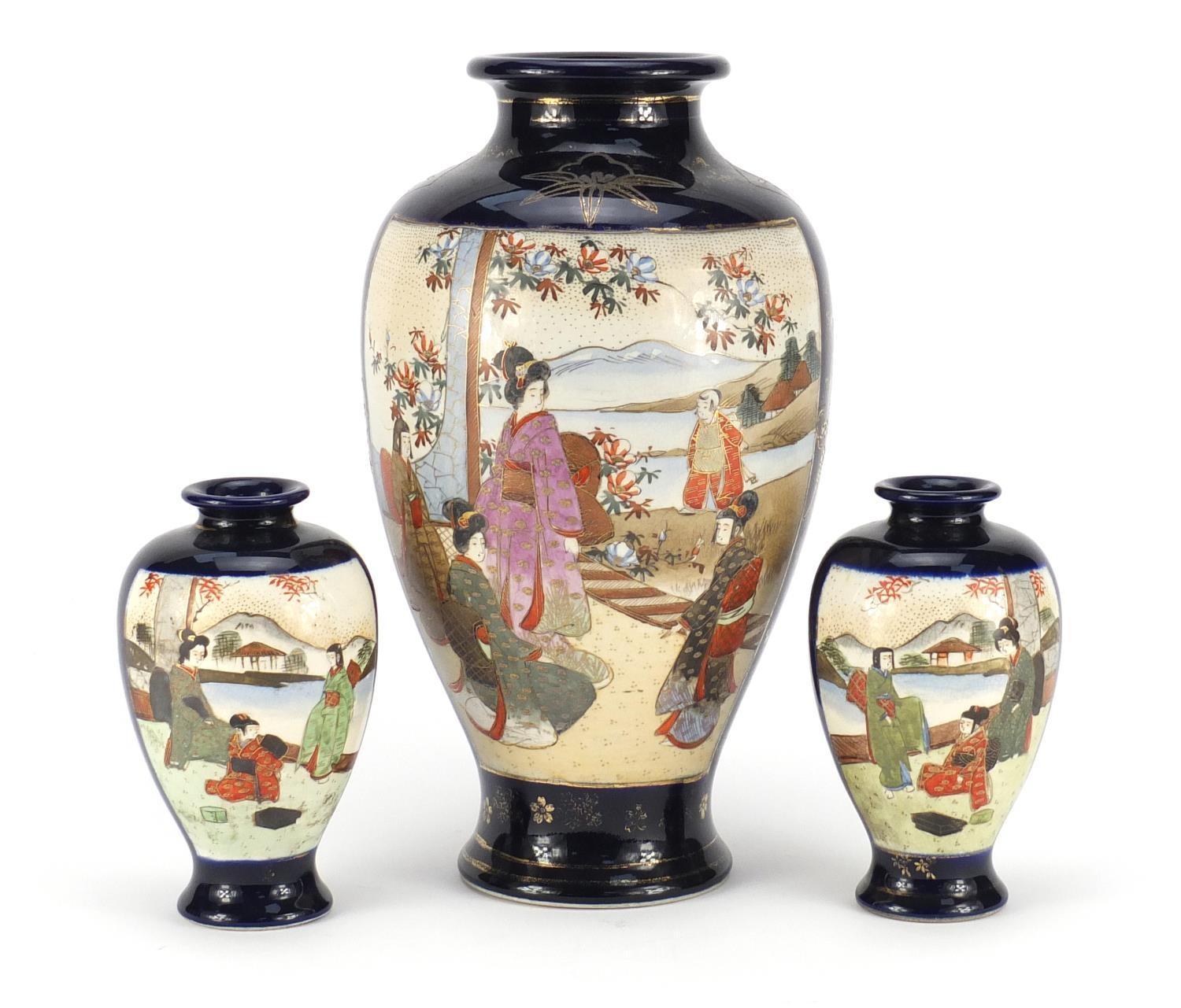 Three Japanese Satsuma pottery vases including a pair, each hand painted with flowers, the largest