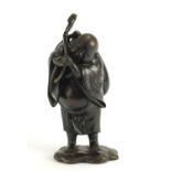 Japanese patinated bronze figure of a man holding a sack, character marks to the reverse, 30cm
