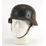 German Military interest tin helmet with decals and leather liner, inscriptions and impressed