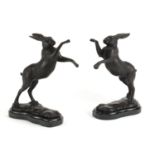 Pair of patinated bronze hares raised on shaped marble bases, each 29.5cm high :For Further