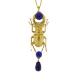 Egyptian Revival brass stag beetle pendant set with cabochon lapis lazuli stones on a necklace,