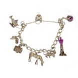 Silver charm bracelet with a selection of mostly silver charms including lighthouse, horse and