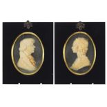 Pair of Georgian style wax portrait miniatures by Leslie Ray, housed in ebonised frames, the