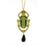 Egyptian Revival brass and enamel beetle pendant with black agate drop on a necklace, the pendant