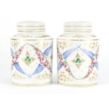 Pair of continental porcelain canisters with covers, hand painted and gilded with flowers, 17cm high