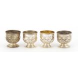 Set of four silver egg cups with embossed decoration by Henry Matthews, Birmingham 1909, 4.7cm high,