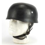 German Military interest tin helmet with decal and leather liner, stamped marks and impressed