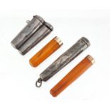 Two silver cheroot cases, housing two amber coloured cheroots with 9ct gold mounts, the largest