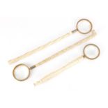 Three Victorian carved ivory parasol handles converted to magnifying glasses, including one