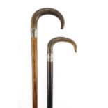 Two horn handled walking sticks with silver collars, possibly rhinoceros horn, the largest 92cm in