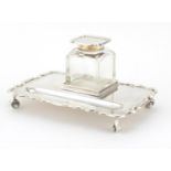 Rectangular silver desk stand by Walk & Hall, raised on four scroll feet, with cut glass inkwell,