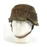 German Military interest tin helmet with cover and leather liner, impressed marks to the interior :