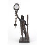 Military interest patinated bronze swinging clock in the form of a pilot holding a propeller, 38.5cm