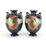 Pair of Japanese Kinjo vases with twin handles, hand painted with panels of landscapes, each 21cm