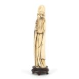 Chinese ivory carving of Shou Lao holding a staff raised on a hardwood stand, overall 20cm high :For