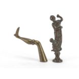 Two Victorian brass pipe tamper's in the form of a maiden with putti and a female leg, the largest