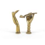Two Victorian brass pipe tamper's in the form of a hand holding a pipe and a leg with boot, the
