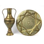 Large Indian brass twin handled vase and circular tray, both embossed and engraved with foliate