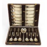 Set of twelve silver plated dessert spoons and forks, housed in a fitted case : For Further